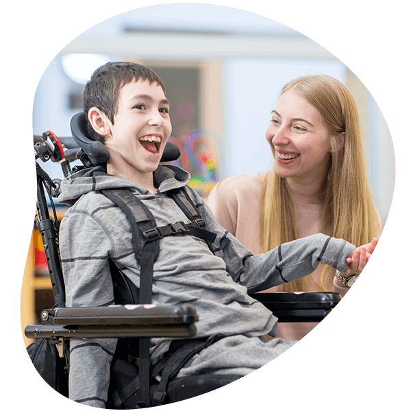 caregiver playing with a little boy that has a mental and physical disability